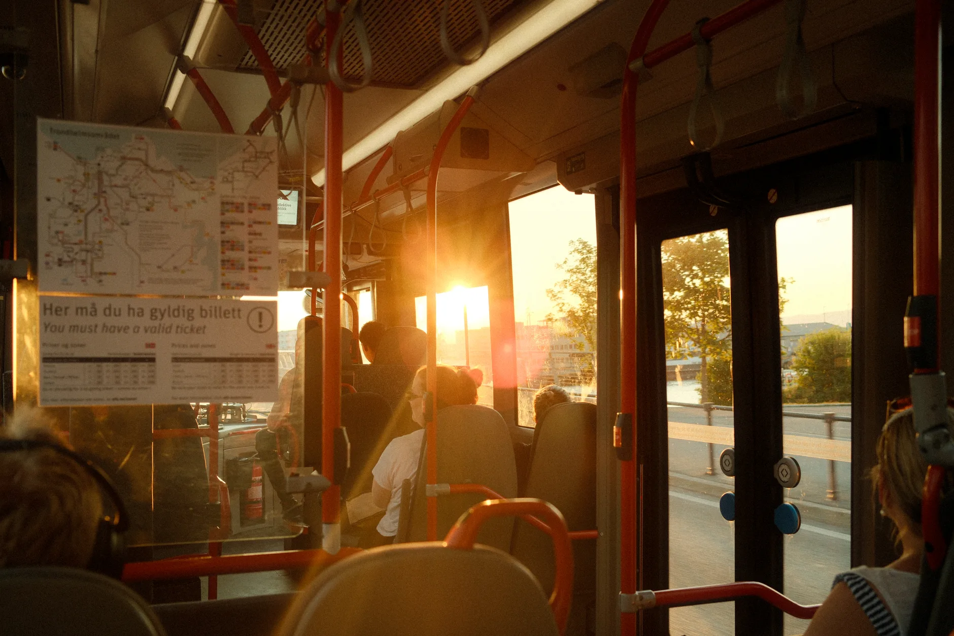 Pasażerowie w warszawskim autobusie miejskim o zachodzie słońca